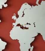 Kırmızı zemin üzerinde gri, gümüş renklerde ülkeleri ve kıtaları gösteren Ofis Duvar Dekorasyon Metal Dünya Haritası Prata
