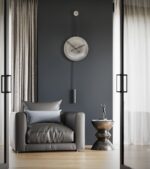 Duvar saati modelleri arasında trend olan siyah akrep yelkovanlı siyah halatlı antik gümüş dekoratif saat Avvolo 45 sandalye ve masa olan odada duvarda asılı durmakta