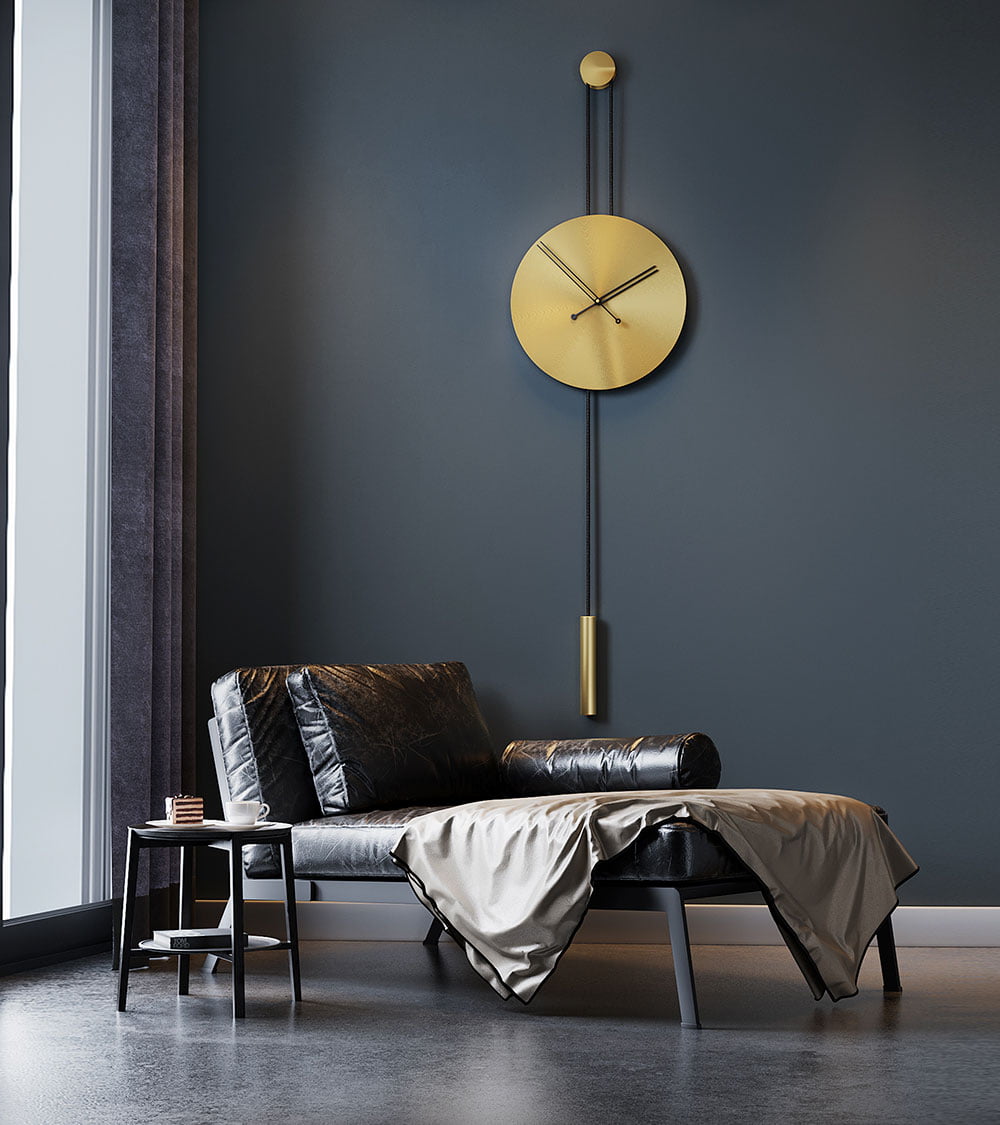 Duvar saati modelleri arasında trend olan siyah akrep yelkovanlı siyah halatlı mat gold altın dekoratif saat Avvolo 45 sandalye ve masa olan odada duvarda asılı durmakta
